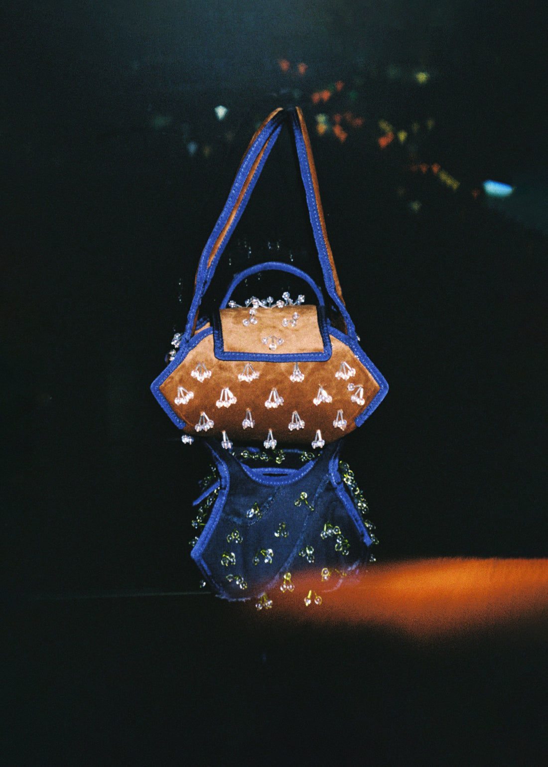 The Swing Fabric Bag in Color Warm Brown Velvet with Crystal Tassel Beads stacked onto The Swing Fabric Bag in Color Waved Pattern Indigo Denim with Crystal Tassel Beads