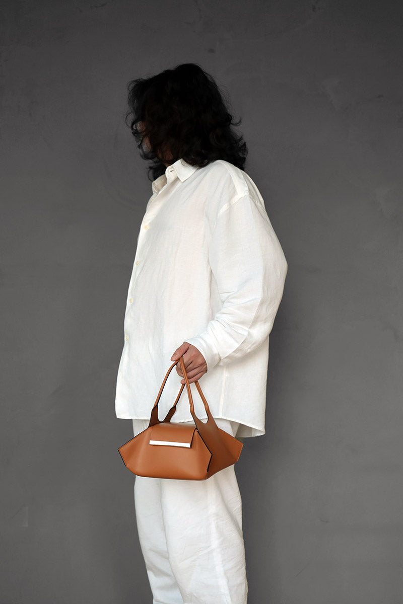 Male Model carrying the Kutchra Leather Handbag in color Tan