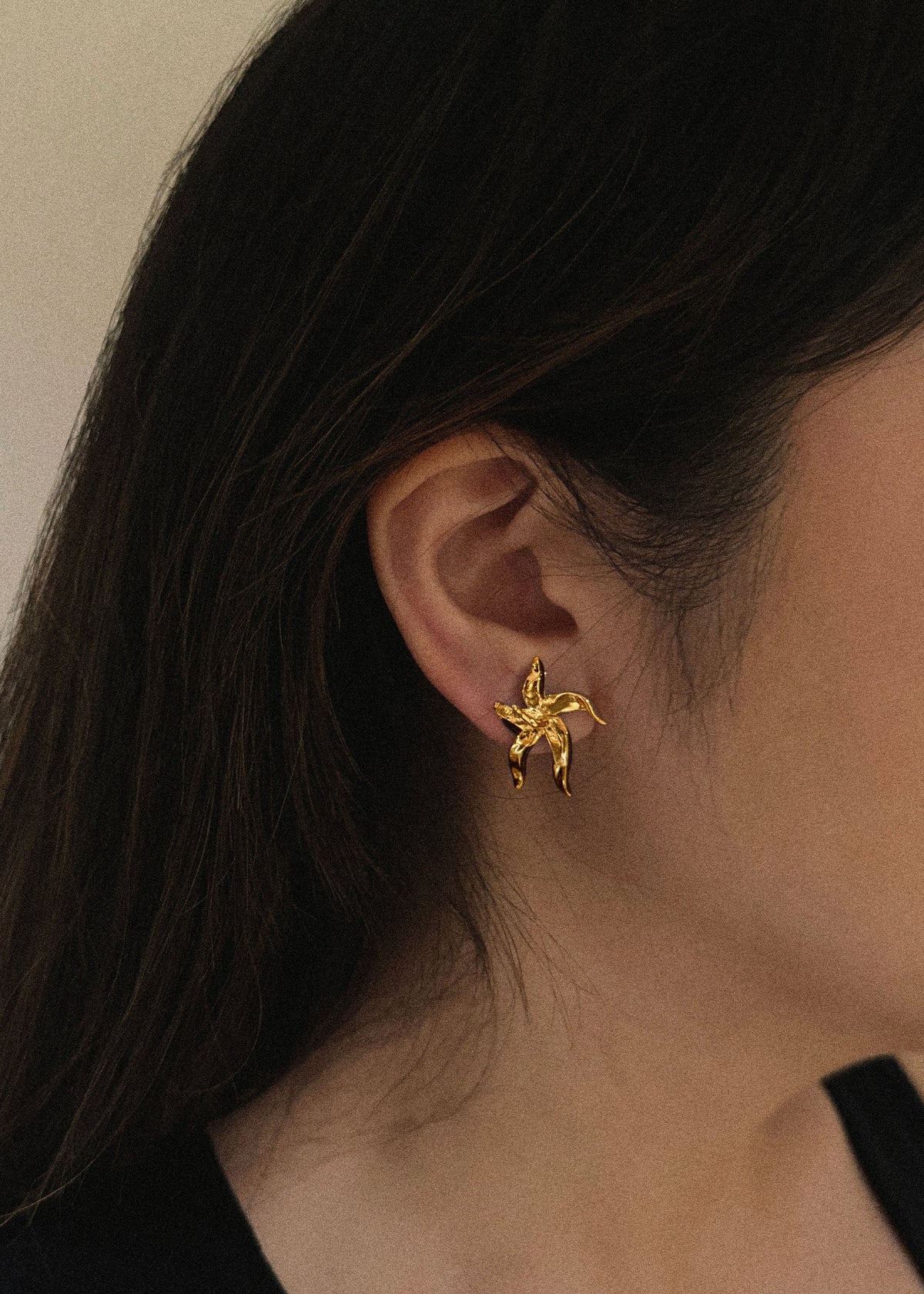 Model Wearing Stem Ear ring (Star shaped) rendered in Gold Metal