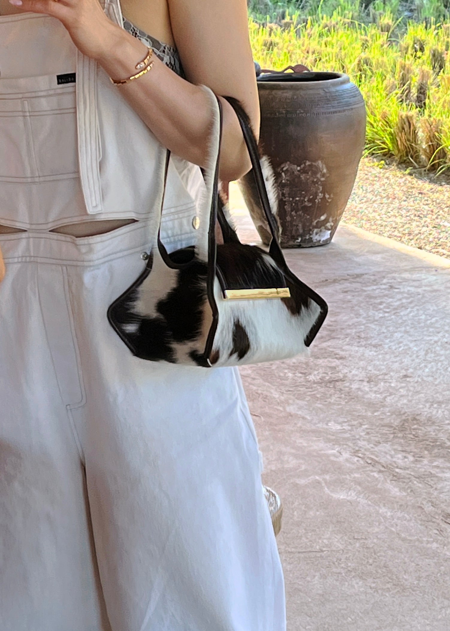 Person wearing the Swing Leather Handbag rendered in Brown and White Spotted Pony Hair. 